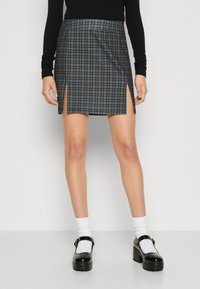 Svart och grått houndstooth-minikjol med framklippningar, med en mjuk textur. Buren med vita strumpor och svarta plattformsskor.