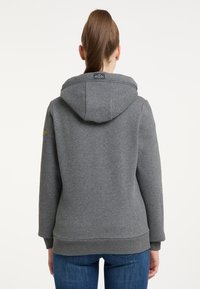 Sudadera gris hecha de una tela suave, con una gran capucha, puños y dobladillo acanalados, y una etiqueta de logo en la parte posterior del cuello.