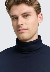 Marineblauer Rollkragenpullover aus glattem Stoff, eng anliegendes Design mit hohem Kragen und minimalen Steppdetails.