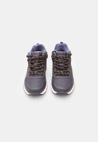 Scarpe da ginnastica blu navy con parte superiore in sintetico testurizzato, suola in gomma beige e lacci marroni. Presentano un colletto imbottito e un logo sulla linguetta.