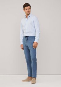 Lichtblauw geruit overhemden met knoop, slim fit, gecombineerd met lichtblauwe broek met trekkoord en beige instappers.