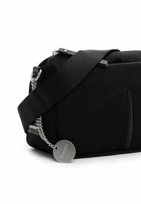 Borsa a spalla nera in tessuto con una consistenza morbida, chiusura con zip, tracolla regolabile e accessori in metallo colore argento. Presenta un charm con logo.