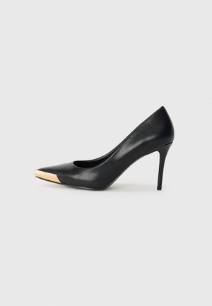 Black leather high-heeled pump with a pointed toe; features a metallic gold accent on the toe cap. Smooth surface with a sleek design.