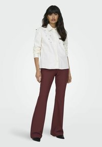 ONLY MIT WEITEM BEINSCHNITT TRAVEL MITTLERE TAILLE AUSGESTELLT - Pantaloni - red mahogany