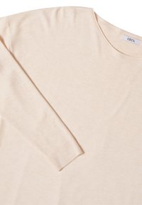 Helles beige Langarmshirt aus weichem Stoff mit lockerer Passform. Verfügt über einen runden Ausschnitt und gerippte Bündchen. Etikett am Kragen.