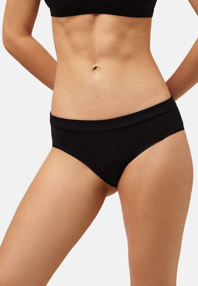 Ropa interior estilo bikini negra hecha de tela suave, con una pretina lisa y ribete de encaje en los bordes. Sin patrones visibles ni marcas.