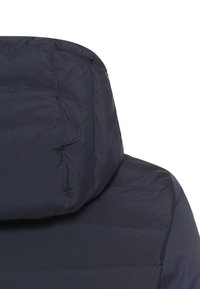 Donker marineblauwe pufferjack met een hoge kraag, voorzien van horizontaal gestikte secties en een gladde textuur. Geen zichtbare metalen onderdelen of accenten.