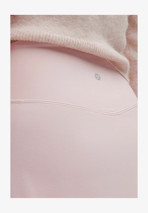 Rosa leggings i stretchtyg, med en mjuk textur och en liten logotyp på baksidan, samt synliga sömdetaljer.