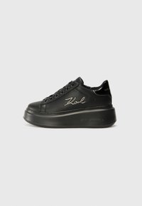 Baskets compensées noires avec une tige en cuir lisse, des lacets plats et un logo "Karl" brodé sur le côté. Bout arrondi et semelle épaisse.