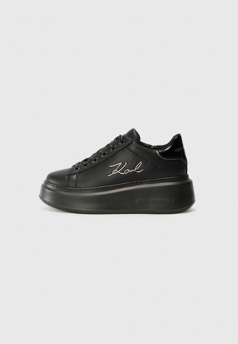 Baskets compensées noires avec une tige en cuir lisse, des lacets plats et un logo "Karl" brodé sur le côté. Bout arrondi et semelle épaisse.