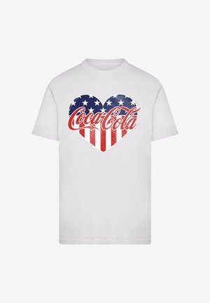 White t-shirt featuring a heart design with red and white stripes, and blue background with white stars, incorporating the Coca-Cola logo.