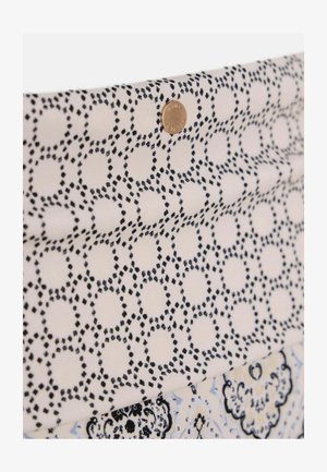 Katoenen stof met een geometrisch patroon van marineblauwe cirkels en stippen op een gebroken witte achtergrond, verfraaid met een kleine gouden stud.