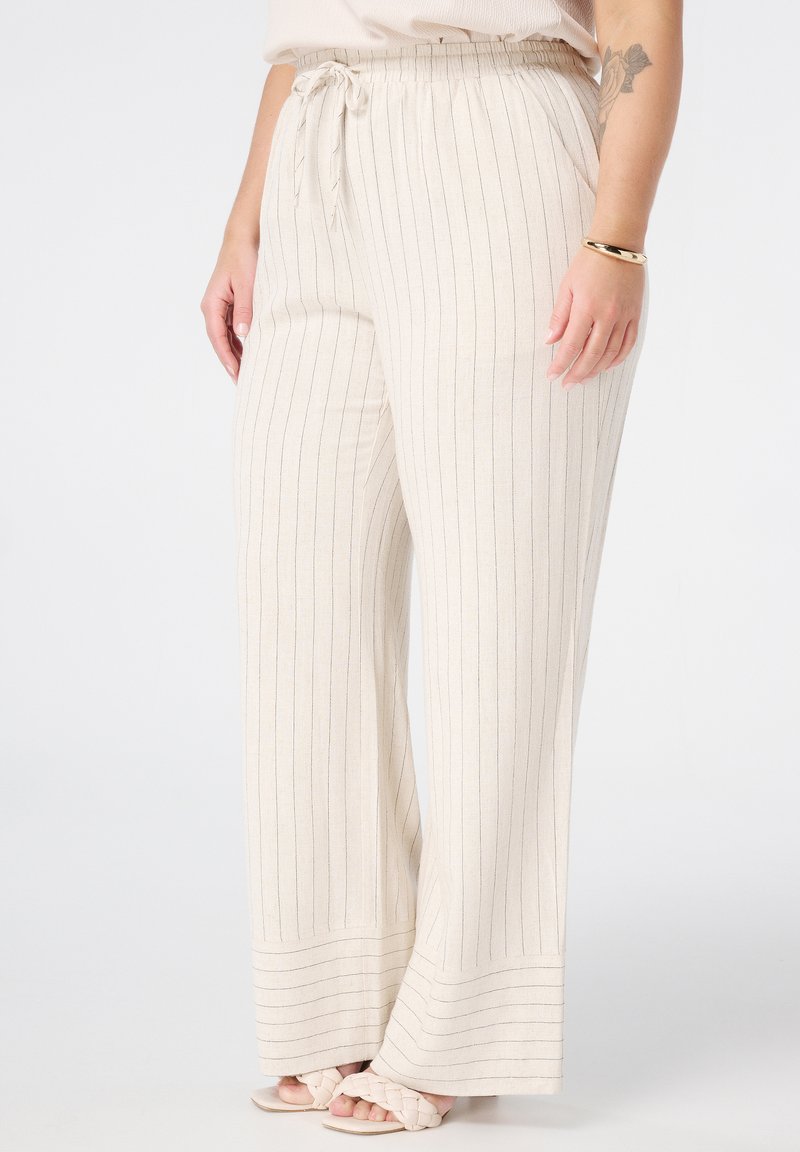 Helle beige weite Hose mit blauen Nadelstreifen, ausgestattet mit einem Kordelzugbund und einem weichTexturierten Stoff. Tragen mit hellen Sandalen.