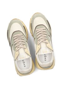 Sneakers with a cream and light green fabric upper, textured accents, beige laces, and a cushioned sole. Features a logo on the insole.