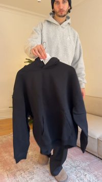 Schwarzer Kapuzenpullover mit einer Fronttasche. Hergestellt aus einem weichen Stoff, hat er eine lockere Passform und sichtbare Nahtdetails.