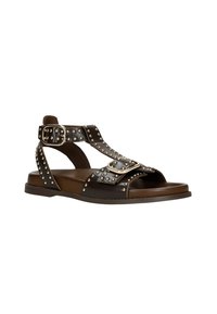 Sandalo in pelle nera con accenti di borchie, una cinghia alla caviglia e due fibbie decorative. Suola piatta con design open toe e sottopiede testurizzato.