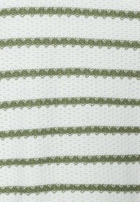 Häkelstoff mit abwechselnden weißen und olivgrünen Streifen. Das Design zeigt gezackte Kanten entlang der grünen Streifen und erzeugt ein strukturiertes Muster.