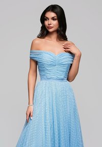 Ljusblå off-shoulder klänning med samlad byst och flödande kjol, med en strukturerad mönster och cinched midja accent.
