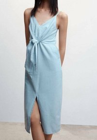 Vaaleansininen, ilman hihnoja oleva mekko, jossa on V-pääntie, etuosan solmitys ja thigh-high halkio. Valmistettu sileästä, kevyestä kankaasta.