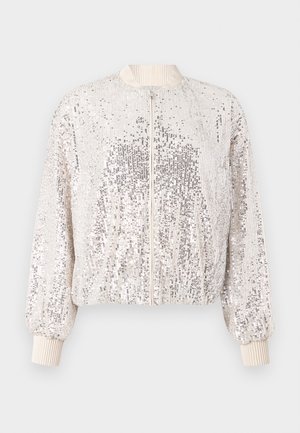 Glanzend zilveren bomberjack met paillettenstof, geribbelde boorden en kraag, en een ritssluiting aan de voorkant. Mid-lengte, losse pasvorm.