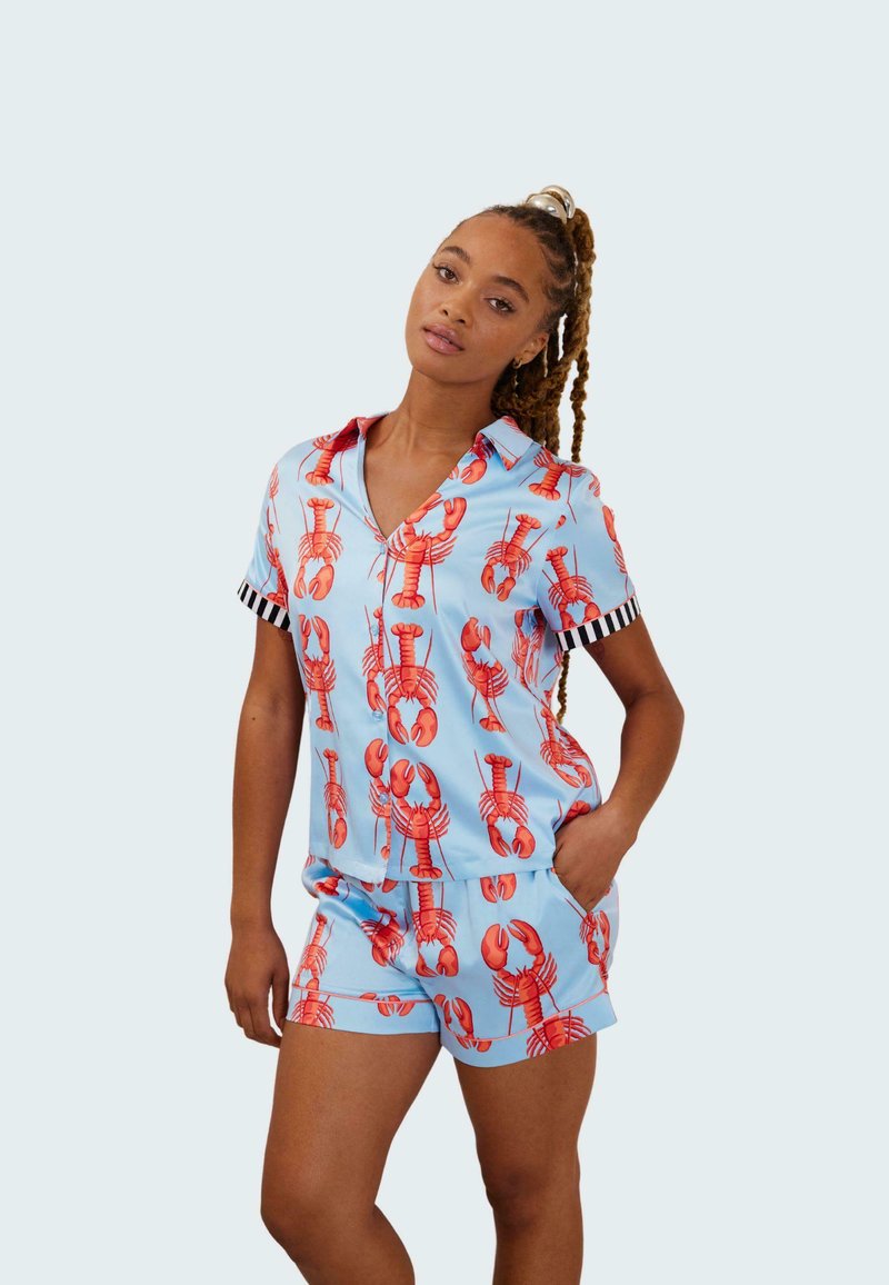 Conjunto de pijama corto con estampado de langostas en azul claro, hecho de un material similar a la seda que presenta acentos en las mangas a rayas negras y blancas.