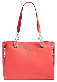 Coralowa torebka z ekoskóry z podwójnymi uchwytami, srebrnym okuciem i wytłoczonym logo marki. Posiada zamykane boki oraz dekoracyjne akcenty.