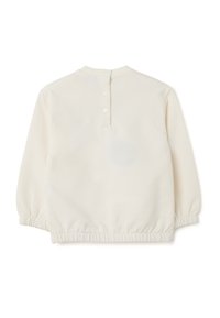 Crème-kleurig babyshirt met lange mouwen, elastische manchetten en zoom, achter sluiting met knopen en drie witte drukknoopjes.