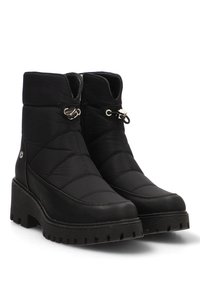 Botas negras hasta el tobillo hechas de nylon acolchado y cuero sintético, con suela de goma plana, herrajes decorativos de color plateado y un diseño aerodinámico.