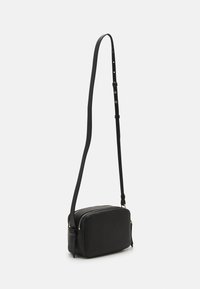 Borsa a tracolla in pelle nera con due scomparti con cerniera, forma rettangolare, tracolla regolabile e accessori in metallo color oro.