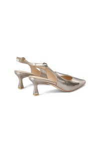 Scarpe con tacco slingback in argento metallico, con punta affilata, tacco basso a campana e design con ritagli, dotate di cinturino regolabile alla caviglia.
