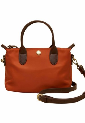 Handtasche in Rostfarbe mit dunkelbraunen Ledergriffen, abnehmbarem Schulterriemen und kleinem, rundem goldfarbenem Logo-Knopf vorne.