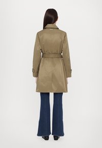 Trench-coat kaki avec une taille ceinturée et des épaulettes, doté d'une texture lisse et d'un col classique, vu de dos.