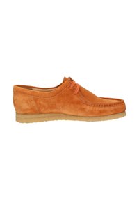 Chaussure en daim orange avec un bout arrondi, semelle en caoutchouc marron et lacets orange contrastants. Détails de couture minimalistes le long des coutures.