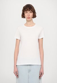 Tricou din bumbac alb cu mâneci scurte și guler rotund. Prezintă un text brodat discret pe piept. Design simplu, potrivit.