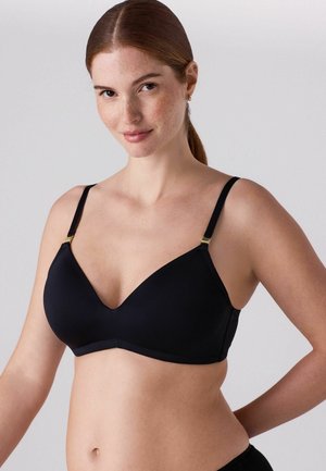 Sutien negru, fără cusături, cu decolteu adânc, bretele reglabile și accente aurii din metal. Material moale și design minimalist.