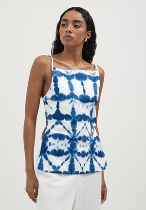 Débardeur tie-dye bleu et blanc avec des bretelles fines et une silhouette ajustée, présentant un tissu texturé et des détails sur les côtés.