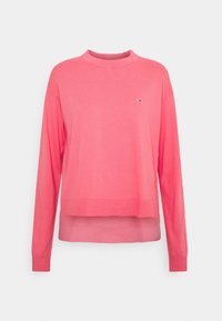 Långärmad rosa tröja med hög hals, ribbad fåll och en liten logga på bröstet, tillverkad av mjuk stickad tyg.