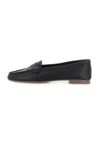 Mocasines de cuero negro con un acabado texturizado, un perfil bajo, costuras decorativas y un pequeño tacón. Diseño simple sin patrones visibles.