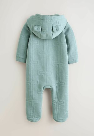 Jasnoniebieski kombinezon z kapturem wykonany z teksturowanej tkaniny z wzorem geometrycznym, z zaokrąglonym kapturem i długimi rękawami.