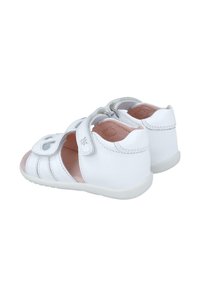 Sandalias de cuero blanco con punta redondeada, correas ajustables y lados descubiertos. Plantilla suave en color rosa y suela exterior texturizada en blanco.