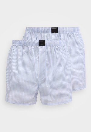 To par med blå og hvite vertikale stripete bomullsboxershorts med elastiske midjebånd og svarte merkeetiketter midt foran.