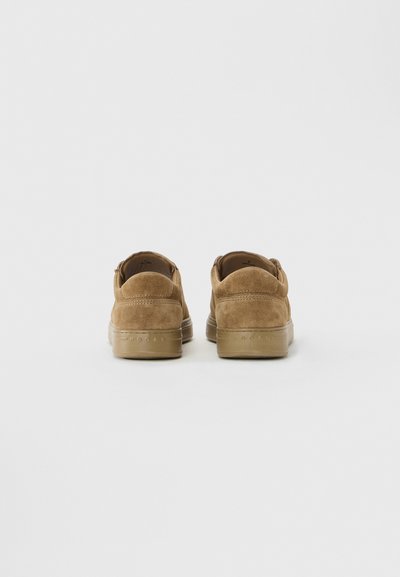 Brown suede sneakers shown from the back, featuring rubber soles and subtle stitching details on a plain white background.