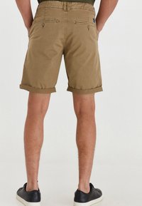 Khaki-Shorts mit umgeschlagenen Säumen, elastischem Bund und Gesäßtaschen. Der Stoff wirkt glatt und leicht, ideal für die Freizeit.