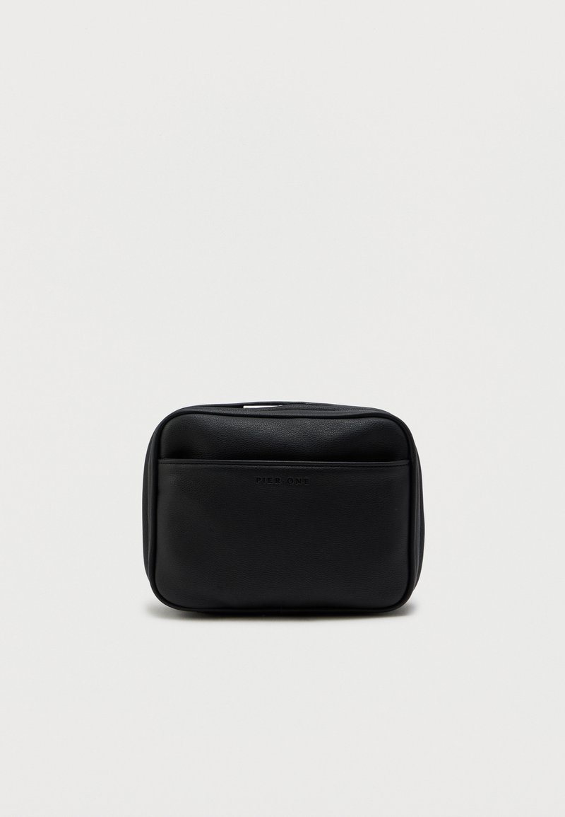 Black leather travel bag with a rectangular shape, featuring a front pocket and a smooth texture. Zipper closure at the top.