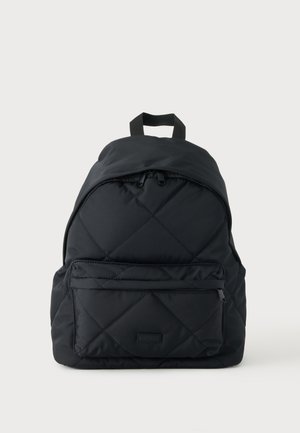 Black quilted backpack with front zip pocket, double top zipper, and a carrying handle against a plain light background.