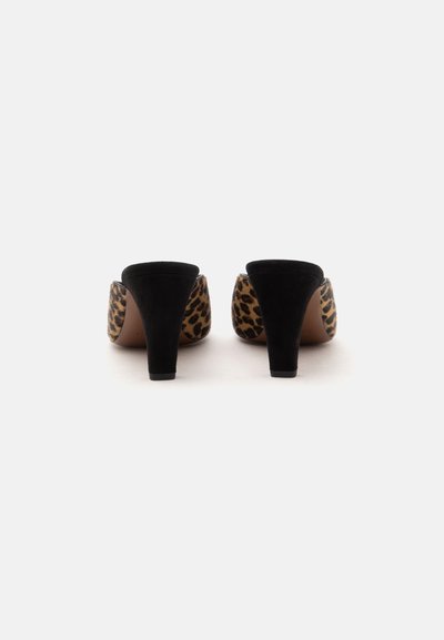 Paire de mules à talons hauts imprimé léopard avec talons en daim noir vues de dos sur fond blanc uni.