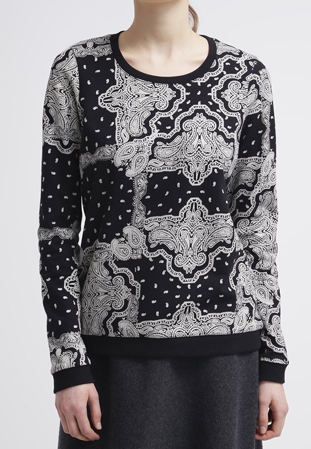 Svart och vit sweatshirt med lång ärm som har ett intrikat paisleymönster med kontrasterande sektioner samt ribbade ärmslut och krage.