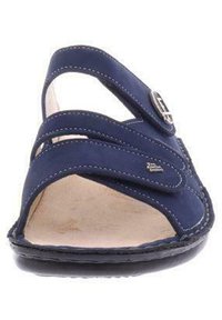Navy blue sandal with crisscross straps, a silver buckle accent, leather upper, and a textured sole. Open-toe design for breathability.