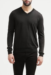 Czarny sweter w serek uszyty z gładkiego materiału, z długimi rękawami i ściągaczami. Projekt jest prosty, bez widocznych wzorów czy logo.