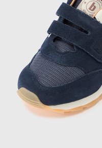 Μπλε αθλητικό παπούτσι από σουέτ και δίχτυ με αυτοκόλλητα λουράκια, στρογγυλερή μύτη, αντιθετική λαστιχένια σόλα και διακριτικά υφασμένα σχέδια.